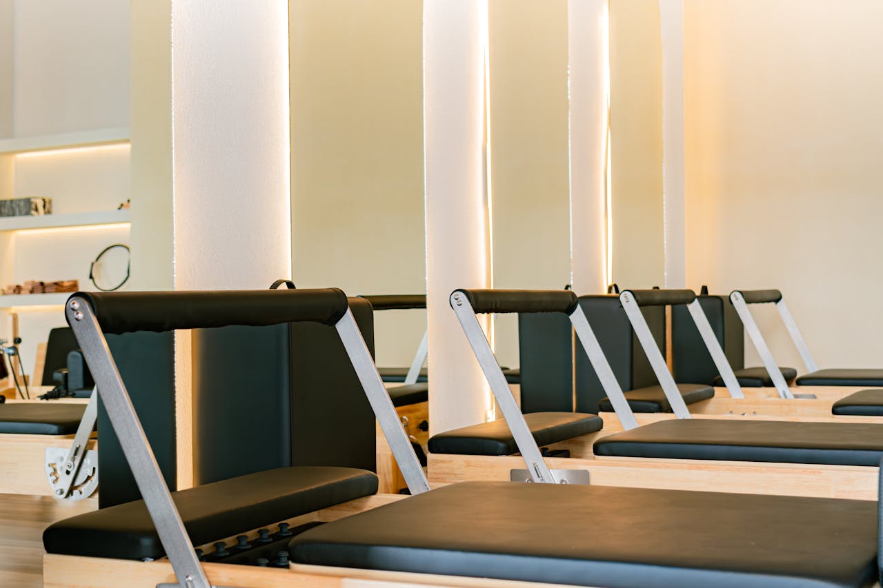 Interior of a modern Pilates studio featuring multiple reformer machines in a calming atmosphere.